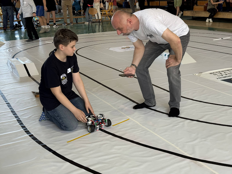 A fekete vonalat követve kellett mihamarabb célba jutni a robotnak miközben akadályokat kerül ki és hídon, libikókán kell átkelnie. Láttunk szép megoldásokat a gyerekektől!