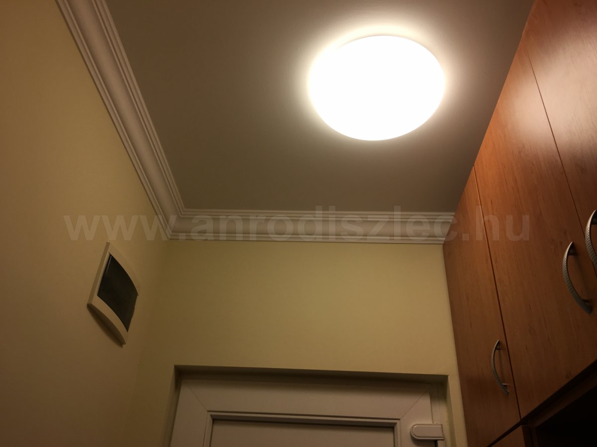 Kis előszoba kerek mennyezeti lámpával, benne körfénycső.