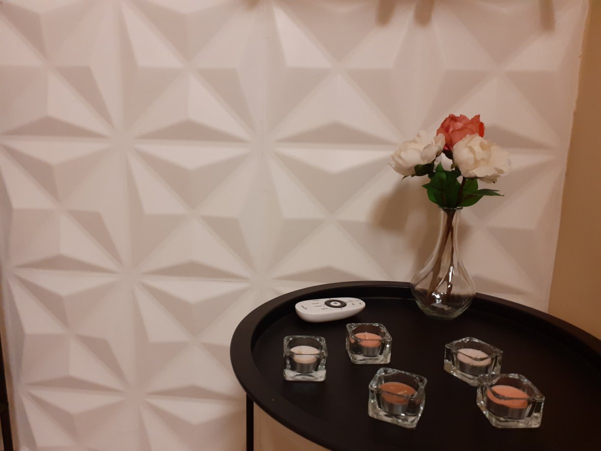 3D falpanel dekoráció, előterében fém asztalkával, rózsás vázával, mécsesekkel 