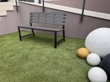 Örökzöld műfű, színes kő golyók és tartós acélvázas pad egy gyógyászati központ kertjében